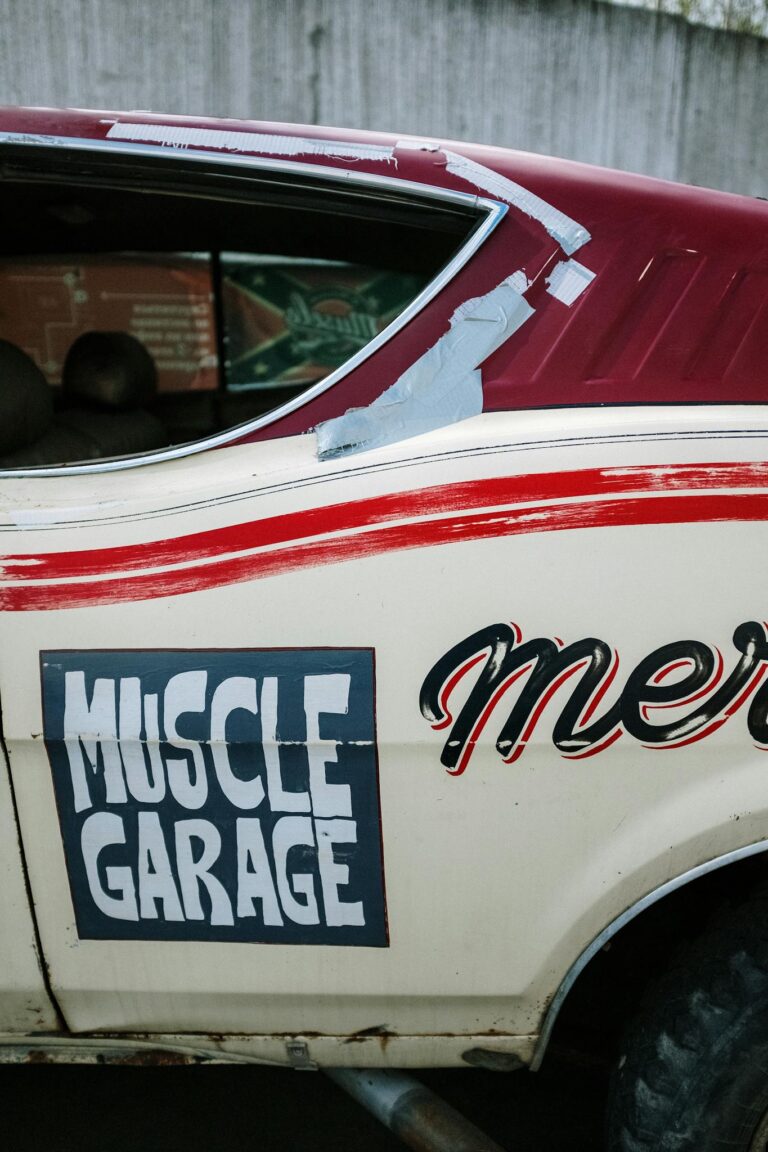 Close-up of a retro muscle car with 'Muscle Garage' signage on the door.